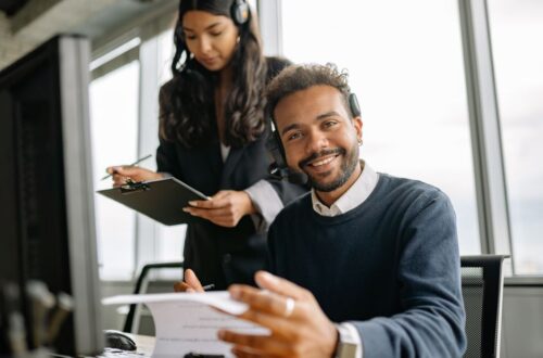 Een HR-specialist bespreekt verzuimbegeleiding met een werkgever en uitzendkrachten op de werkvloer.
